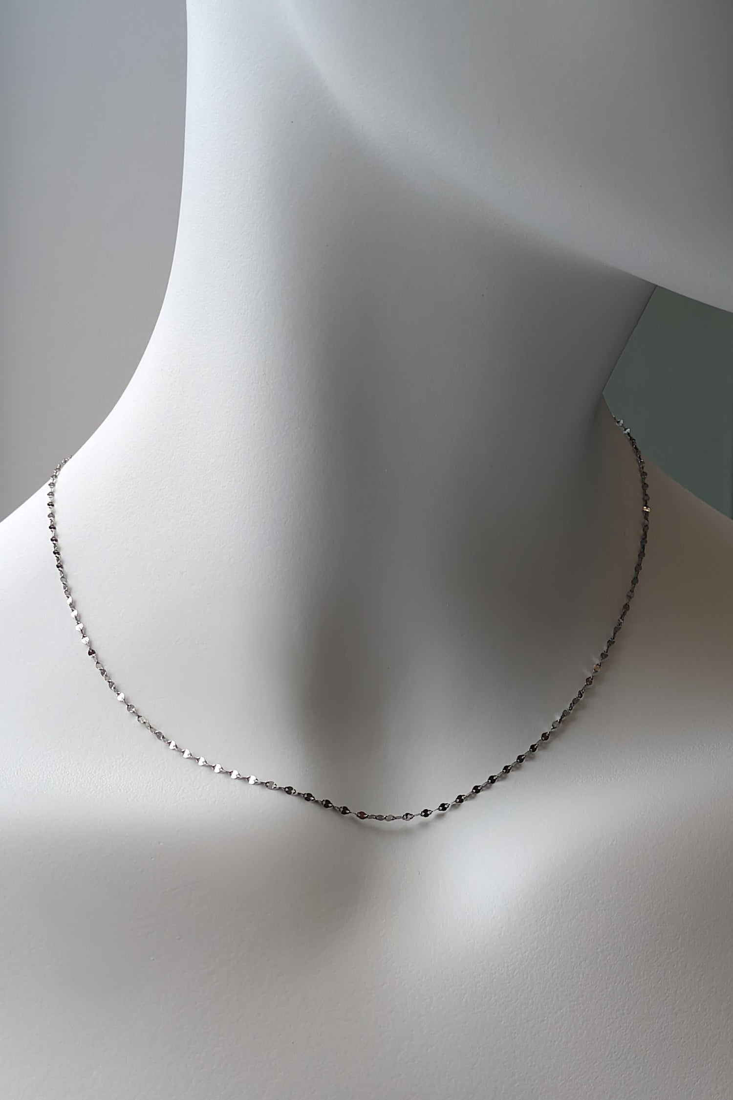 a 16 inch delicate platinum chain that catches the light and sparkles when worn