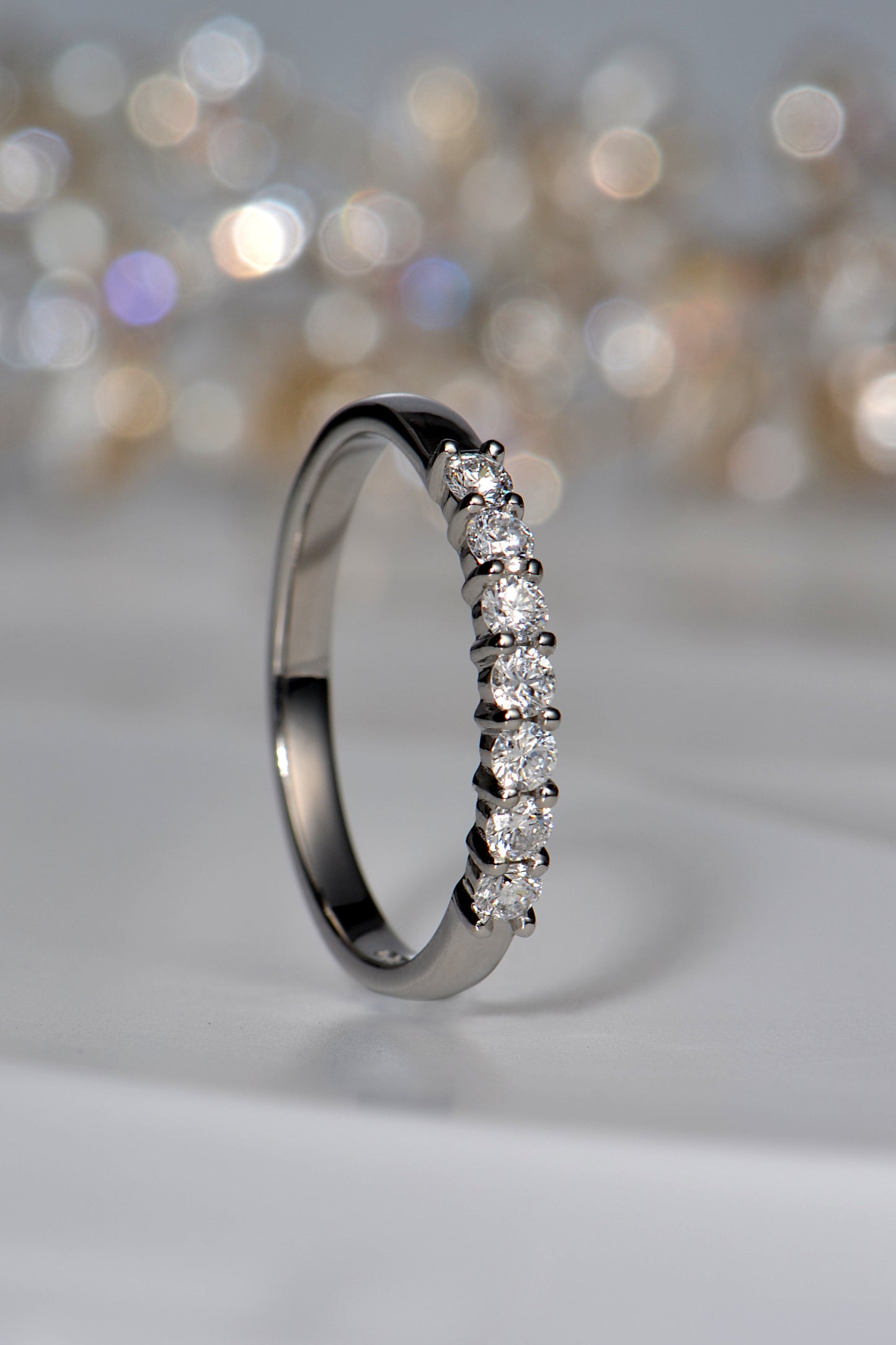 slim platinum ring set with 7 diamonds across the front third of the ring