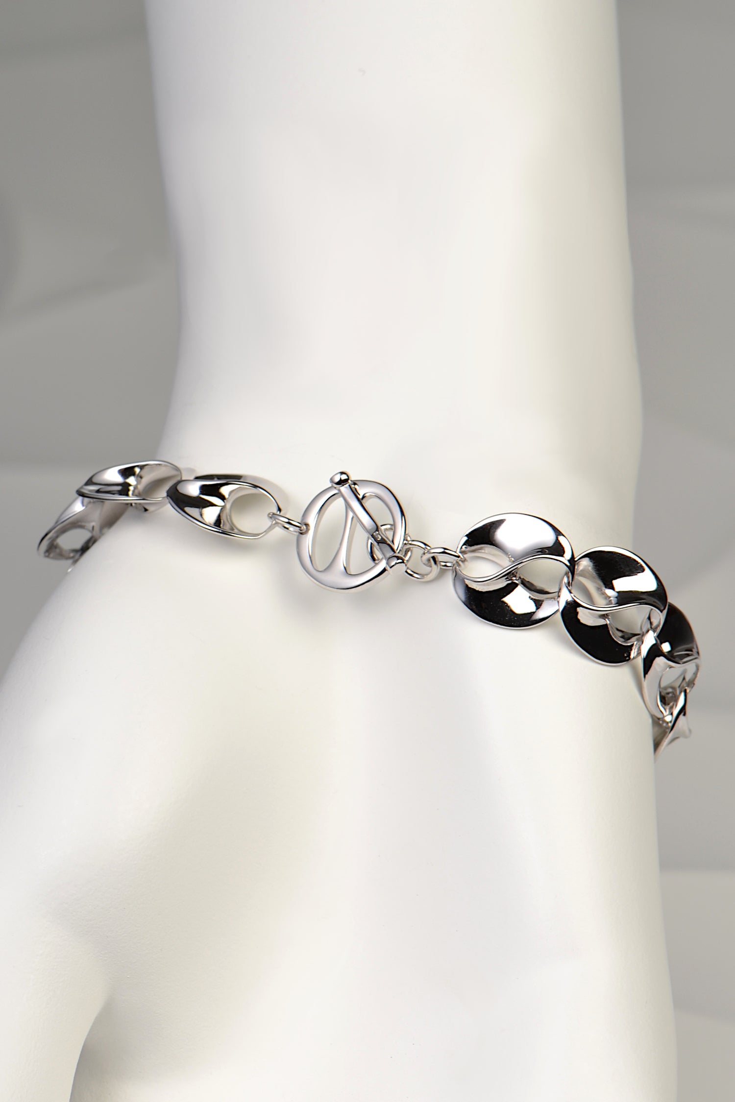 beautiful modern silver designer bracelet for a woman that has a clever decorative t bar clasp by Jorge Revilla