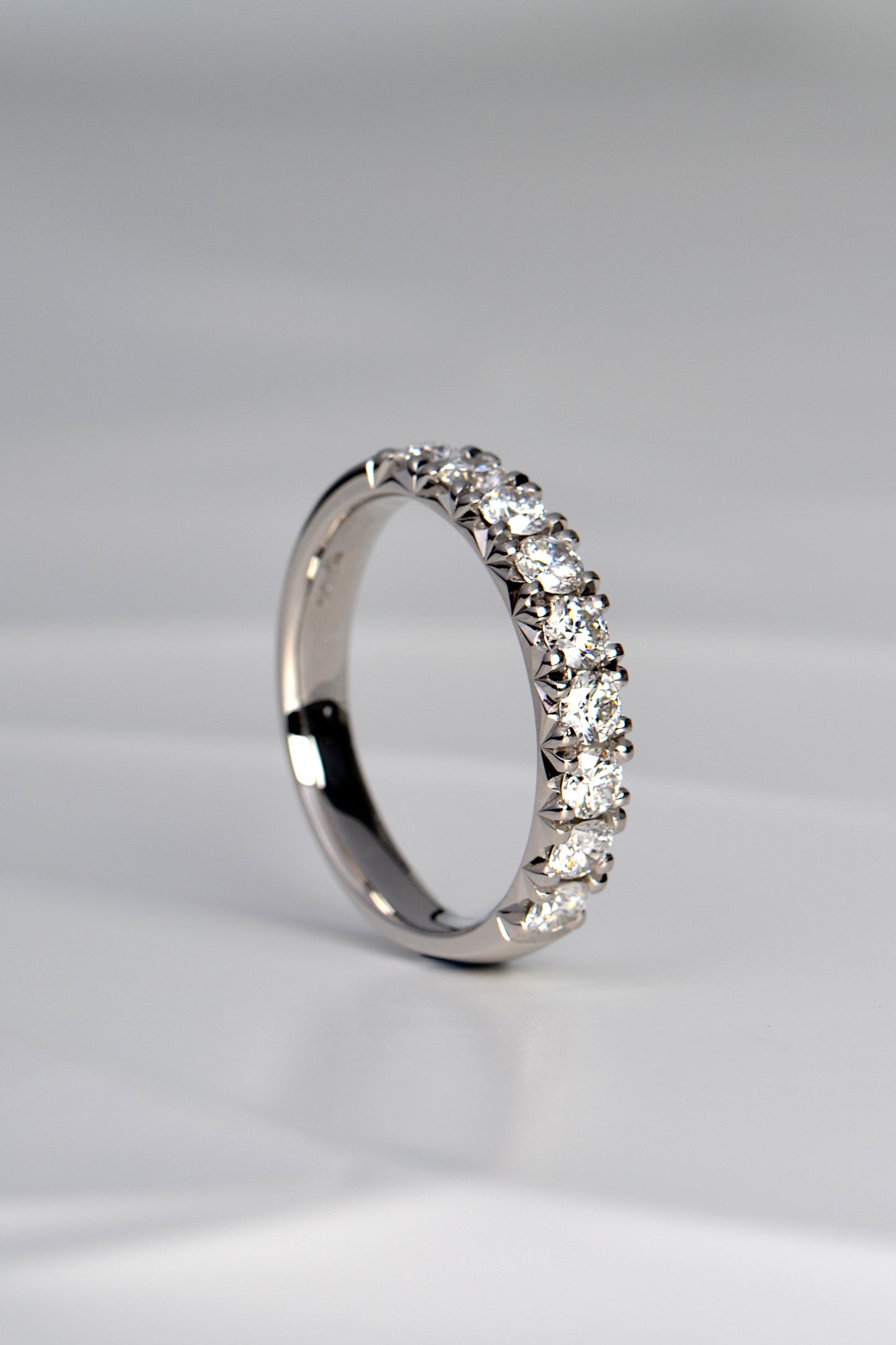 one carat diamond eternity or wedding ring set with nine diamonds across the front half of the ring