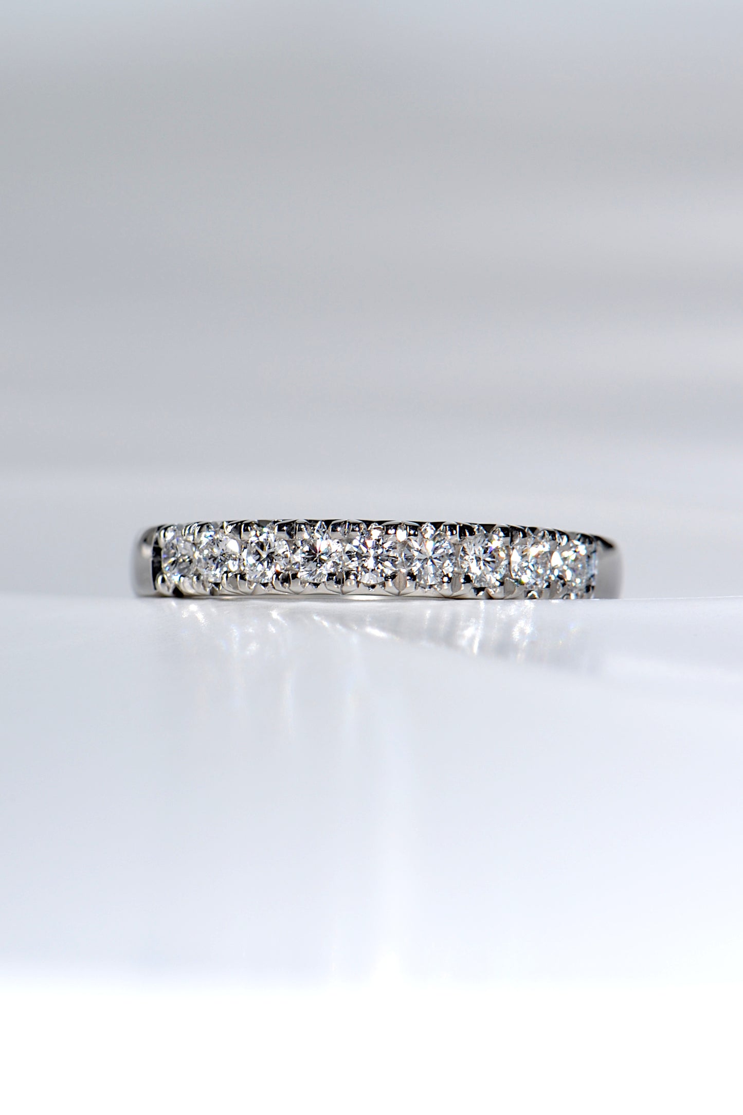 sparkling platinum band with nine round diamonds, ideal as a modern wedding or eternity ring. 