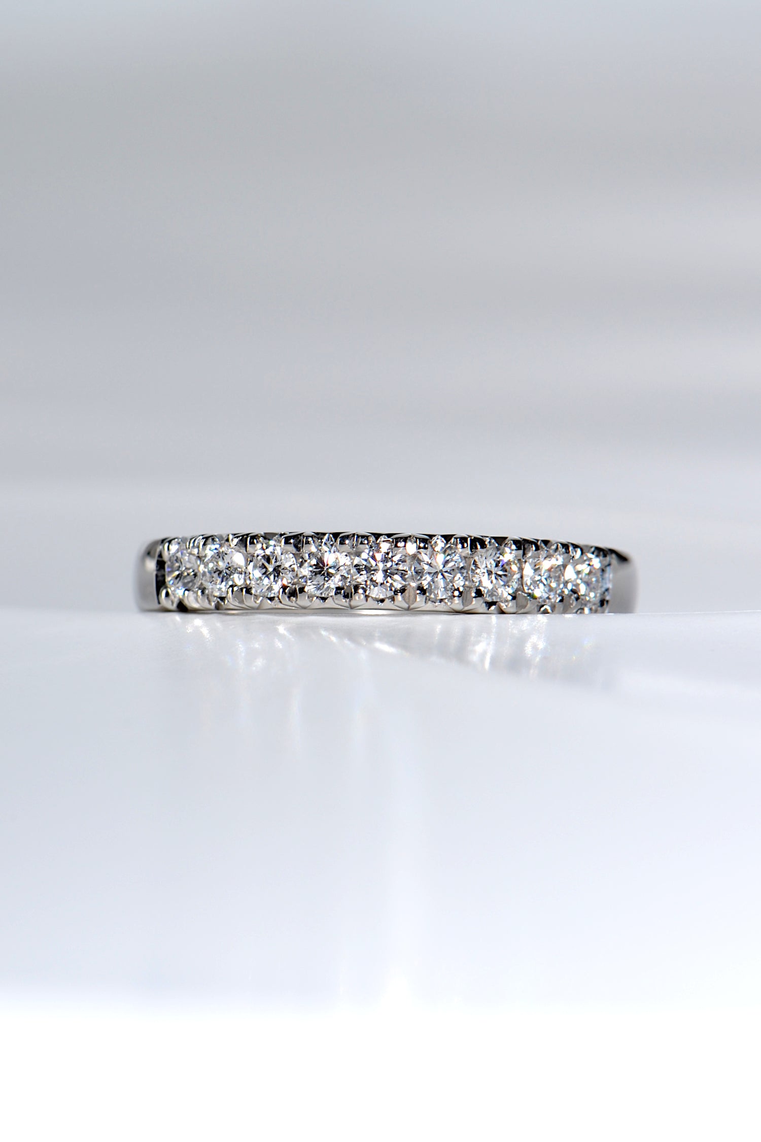 sparkling platinum band with nine round diamonds, ideal as a modern wedding or eternity ring. 