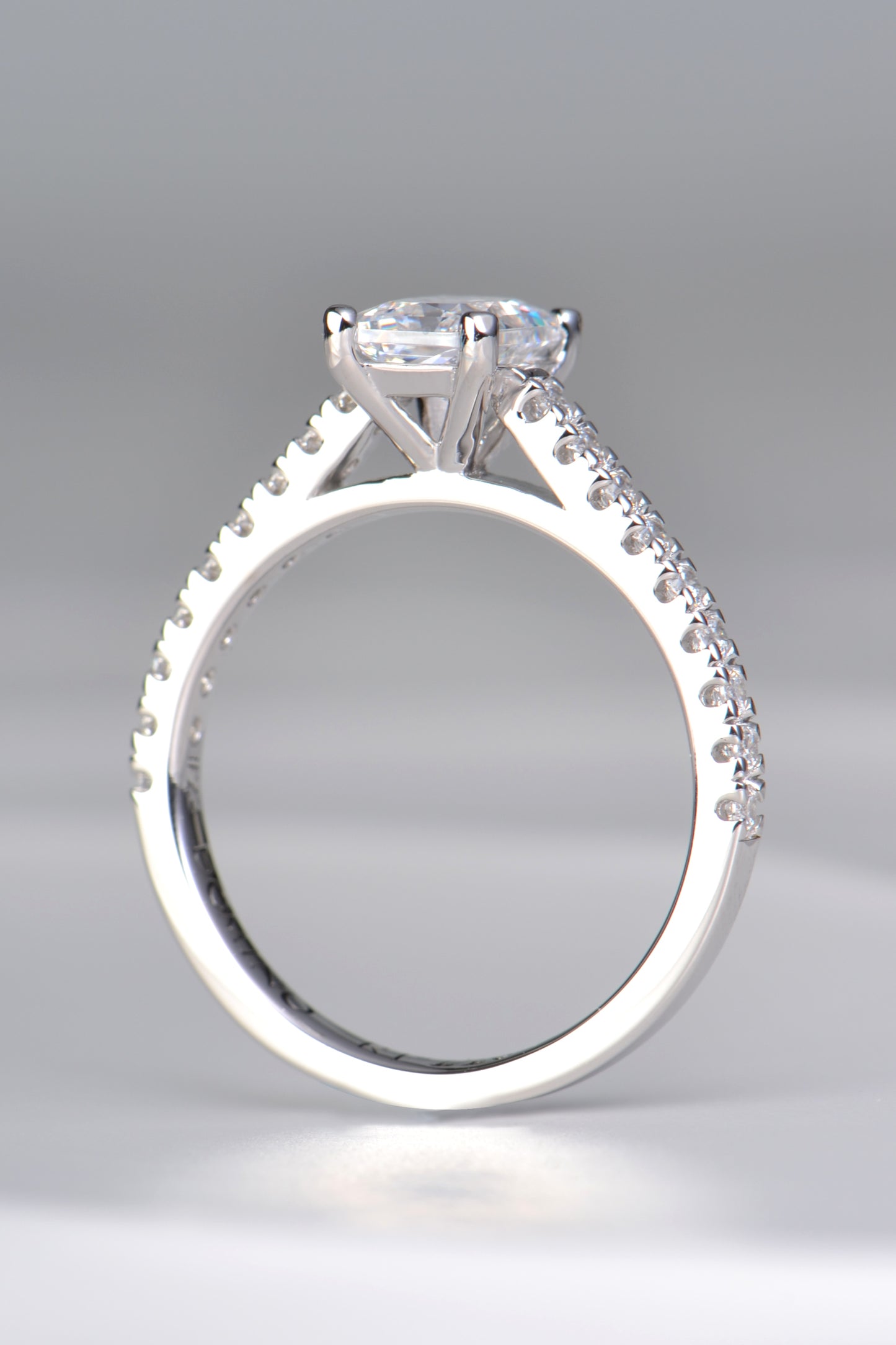 modern emerald cut diamond engagement ring with diamonds in the  shoulders made in the UK