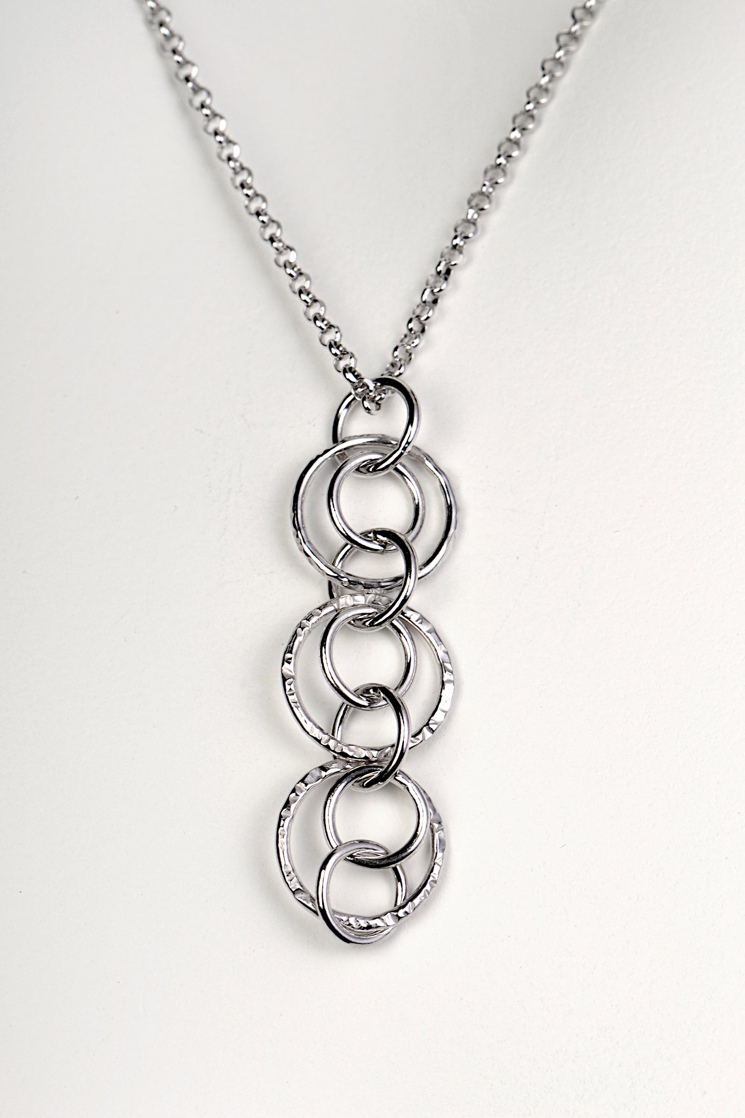 silver circle necklace with three large textured circles joined by seven smaller polished circles from Christine Sadler